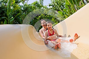 Mother and Daughter Sliding Down Water Slide.