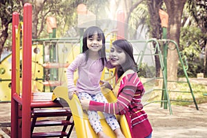 Mother and daughter smiling on slides outdoor