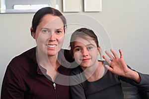 Mother and daughter speaking with relatives in video conference