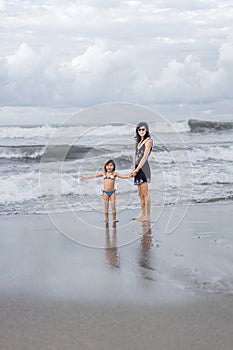 mother and daughter spending time on seashore together