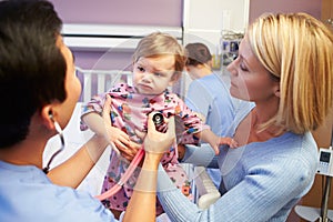 Mother And Daughter With Staff In Pediatric Ward Of Hospital