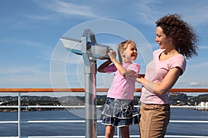 Mother and daughter stand on deck of ship