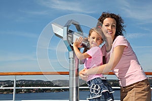 Mother and daughter stand near binoculars