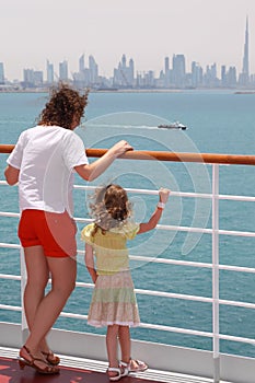 Mother and daughter standing on cruise liner deck