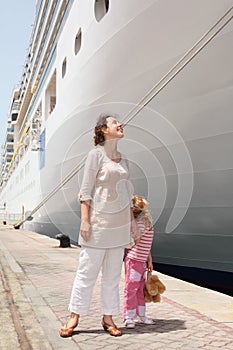 Mother and daughter standing in near cruise liner