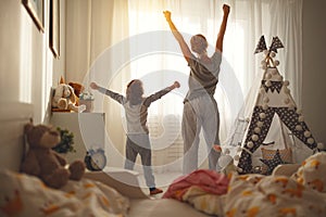 Mother and daughter stretch themselves after waking up in the