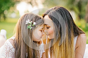 Mother and daughter in the summer in the park. Happy family. Happy Mother`s Day. A postcard for Mother`s Day