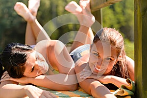 Mother and daughter sunbathing smiling teen friend