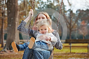 Mother and daughter in a swing at the park