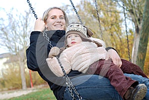 Mother and daughter swinging