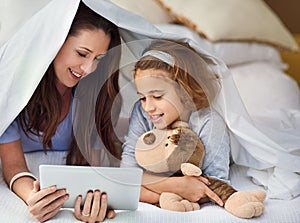 Mother, daughter and tablet in house by bed with movies, video and games online holding teddy bear for mothers day