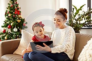 Mother and daughter with tablet pc on christmas