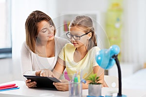 Mother and daughter with tablet pc doing homework