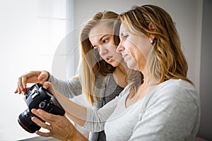 Mother and daughter taking photos and checking them