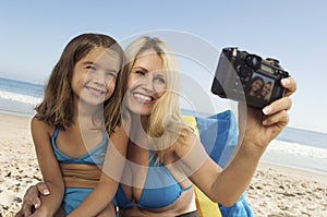 Mother And Daughter Taking Self Portrait On Beach