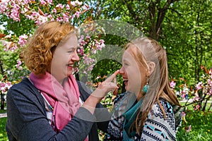 Mother and daughter are talking and laughing in the park