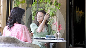 mother and daughter are talking while sitting at the table