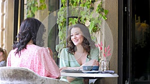 mother and daughter are talking while sitting at the table