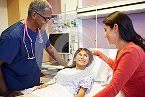 Mother And Daughter Talking To Male Nurse In Hospital Room