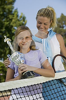 Mother and Daughter at Tennis Net holding trophy