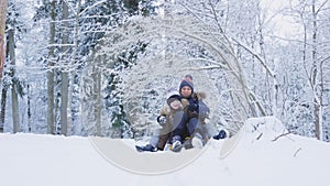 Mother with daughter tobogganing in winter