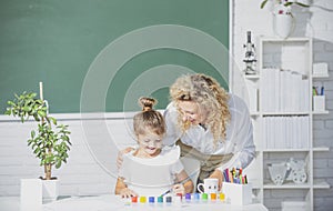 Mother and daughter together paint. Teacher helps the pupil child girl.