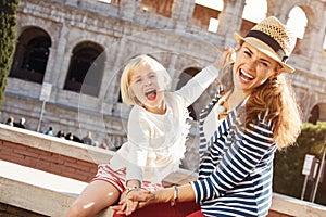 Mother and daughter tourists near Colosseum having fun time