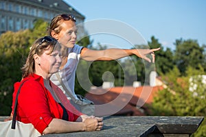 Mother and daughter traveling - two tourists studying a map