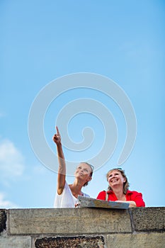 Mother and daughter traveling - two tourists studying a map