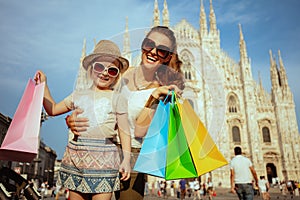 Mother and daughter travellers with colorful shopping bags