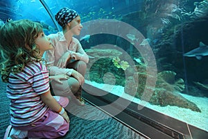 Mother and daughter in underwater aquarium tunn