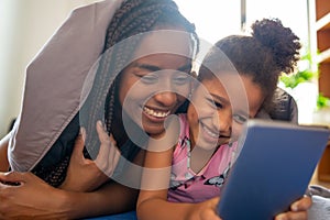 Mother and daughter using digital tablet at home. photo