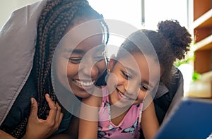 Mother and daughter using digital tablet at home. photo