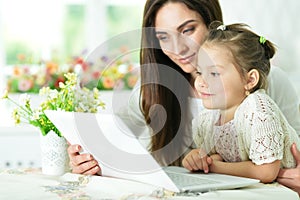 Mother and daughter using laptop