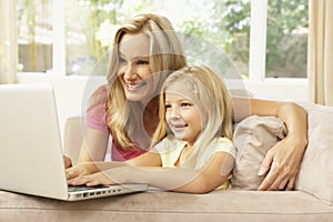 Mother And Daughter Using Laptop At Home