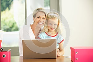 Mother And Daughter Using Laptop At Home