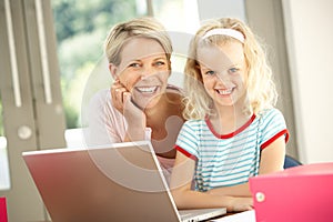 Mother And Daughter Using Laptop At Home