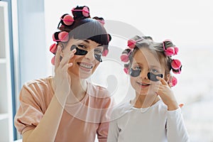 Mother and daughter using patches while relaxing at home.