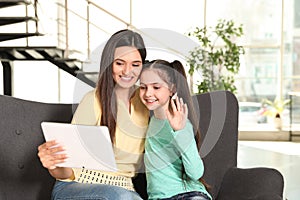 Mother and daughter using video chat on tablet