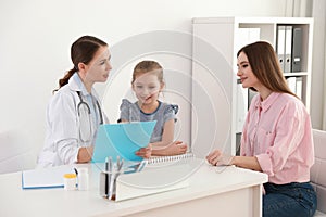 Mother and daughter visiting pediatrician. Doctor working with patient