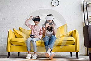 mother and daughter in vr headsets playing video games at home