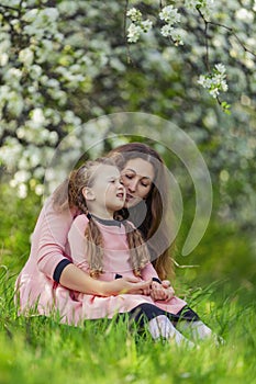 mother and daughter walk through a blooming garden