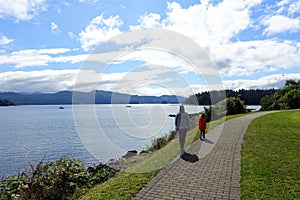 A mother and daughter walking along the boardwalk in Queen Charlotte, Haida Gwaii, Canada,