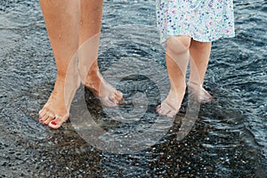 Mother and daughter walking along the seashore