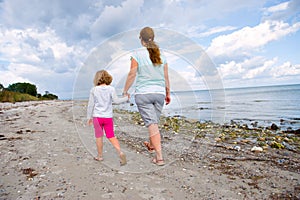 Mother and daughter walking on the beach