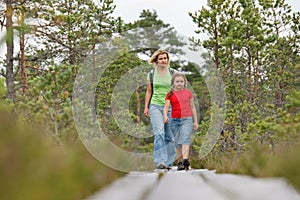 Mother and daughter walking in forest