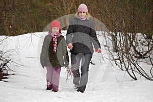 Mother and daughter walking in forest