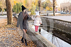 Mother and daughter walking in the Park and enjoying the beautiful autumn nature together