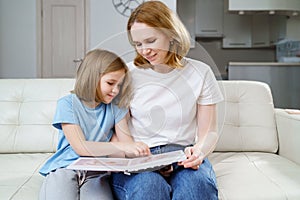 mother and daughter watch photobook from discharge of newborn baby