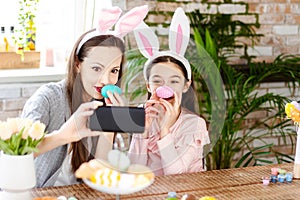 Mother and daughter wearing bunny ears doing selfie